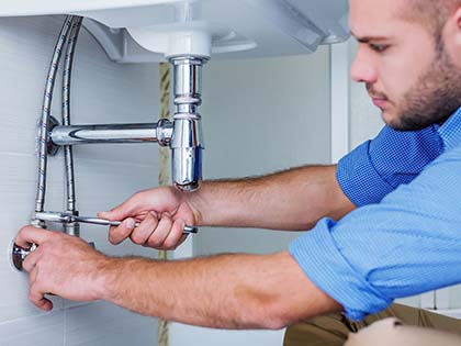 plumber cleaning a bathroom sink drain